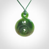 Hand carved New Zealand Jade Twist with Koru heart pendant. Unique Jade jewellery online for sale. Hand made Jade Twist with Koru, provided on adjustable cords and packaged in a woven kete pouch.